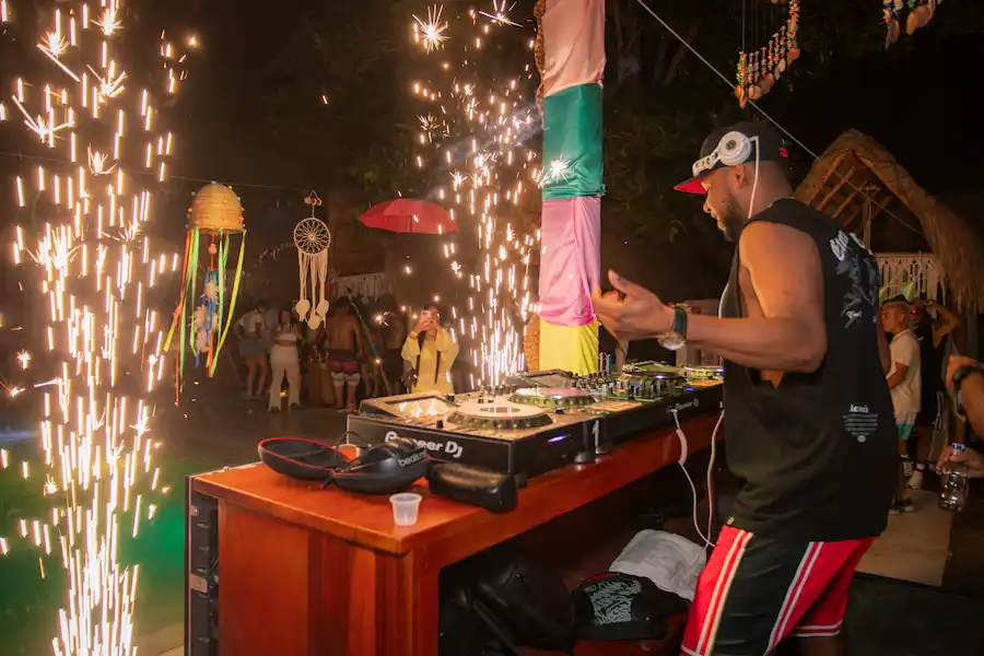 DJ en vivo durante evento nocturno en Vistamar Beach Club en Coveñas, con fuegos artificiales y ambiente festivo.